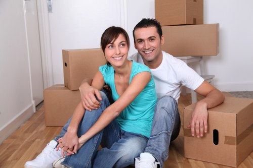 Local removals crew carrying household items through a narrow staircase